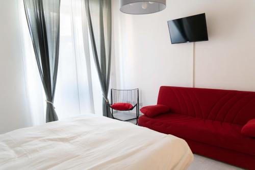 uma sala de estar com um sofá vermelho e uma televisão em Re di Roma bright home em Roma