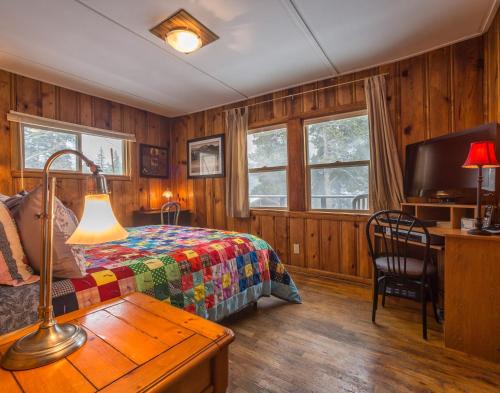 - une chambre avec un lit et une table avec une lampe dans l'établissement Zuni's Cabin, à Leadville