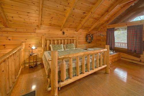 a bedroom of a log cabin with a bed in it at Hanky Panky in Pigeon Forge
