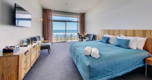 Un pat sau paturi într-o cameră la Beachfront Hotel Hokitika