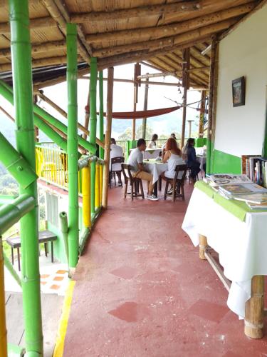 a group of people sitting at a table in a building at Hostal y Camping Los Girasoles in Salento