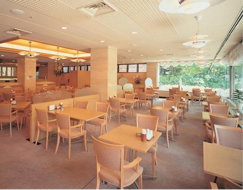 a restaurant with tables and chairs in a room at Hotel Sapporo Sun Plaza in Sapporo