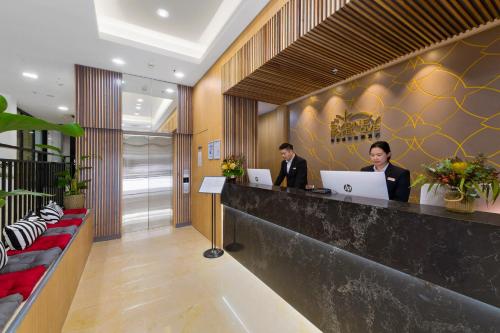 two people sitting at a counter with their laptops at YEHS Hotel Sydney QVB in Sydney