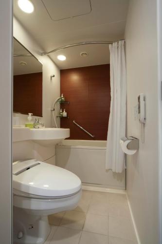 a bathroom with a toilet and a tub and a sink at Hotel Granvia Osaka-JR Hotel Group in Osaka