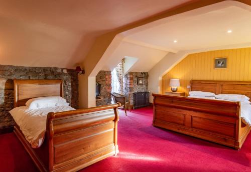 two beds in a room with red carpet at Clenaghans in Moira