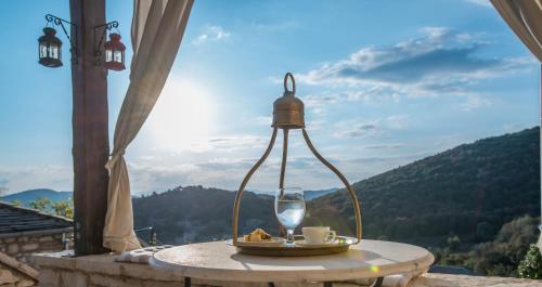 a table with a plate of food and a wine glass at Pirrion Wellness Boutique Hotel in Ano Pedina