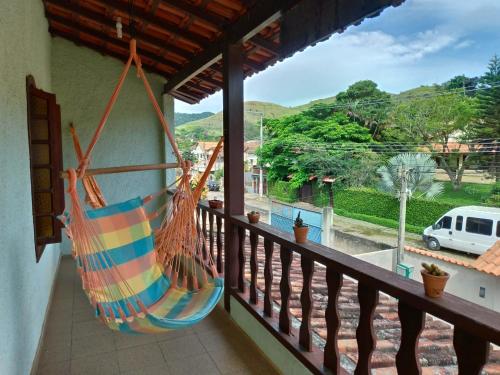 a hammock hanging on a balcony with a view at Casa em Miguel Pereira in Miguel Pereira