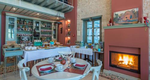 een eetkamer met een open haard en een tafel en stoelen bij Pirrion Wellness Boutique Hotel in Ano Pedina
