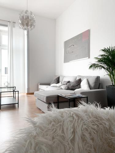 ein weißes Wohnzimmer mit Sofa und Tisch in der Unterkunft Atelier 3 - Boutique Rooms in Loulé