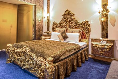 een gouden bed in een kamer met een blauw tapijt bij The We Hotel in Taipei