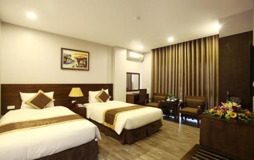 ein Hotelzimmer mit 2 Betten und einem Schreibtisch in der Unterkunft Blue Pearl West Hotel in Hanoi