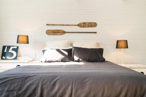a bedroom with a large bed with two lamps at The Oar House in Metung