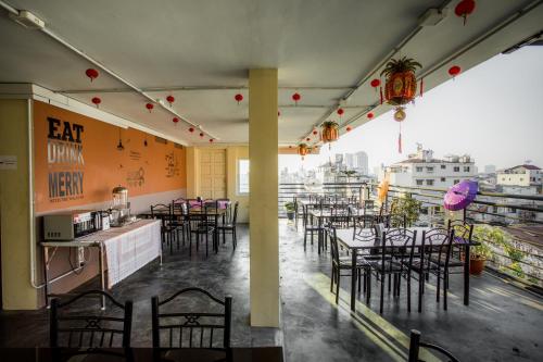 a restaurant with tables and chairs on a balcony at Golden Gate China Town Hotel in Yangon