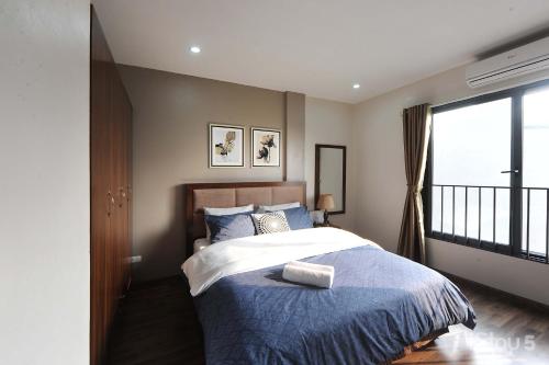 1 dormitorio con cama y ventana grande en ISTAY Hotel Apartment 5, en Hanói