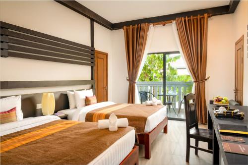 Postel nebo postele na pokoji v ubytování Reveal Angkor Hotel