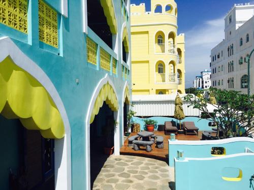 un edificio azul y amarillo con patio en The Domed Tile B&B, en Magong
