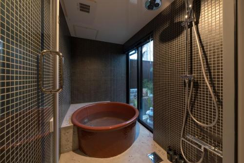 a bathroom with a large copper tub in a shower at Mimari Machiya House in Kanazawa