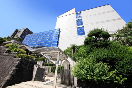 an external view of a building with a glass building at Atami Fuga in Atami