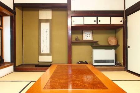 Habitación con mesa de madera en una habitación en Oyado Morinotane en Ina