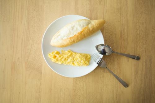 a white plate with a piece of bread and eggs on it at Luna Rossa Villa in Hoi An