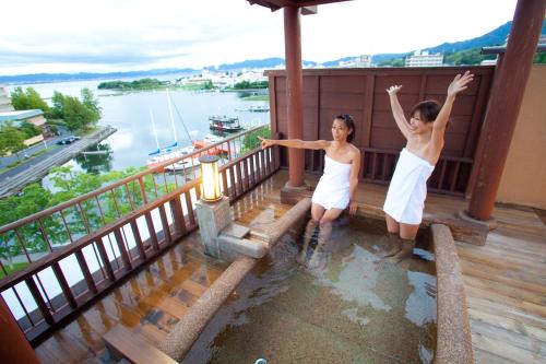 two girls on a balcony with a view of the water at Dantokan Kikunoya in Otsu
