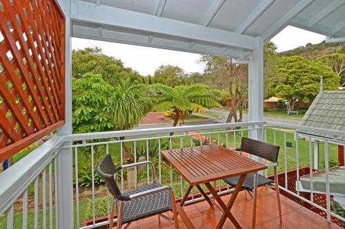 a porch with a wooden table and two chairs at Dolphin Lodge Albany - Self Contained Apartments at Middleton Beach in Albany