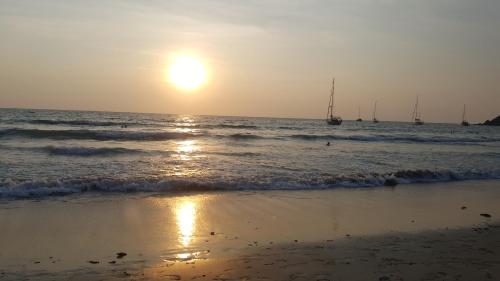 a sunset on the beach with boats in the water at Home No.9 in Ko Lanta