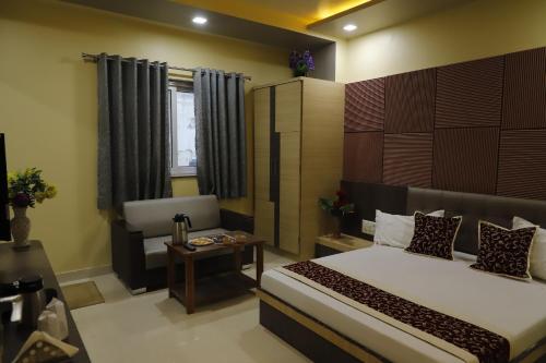 a bedroom with a bed and a chair in it at Hotel Royal Suites in Ajmer
