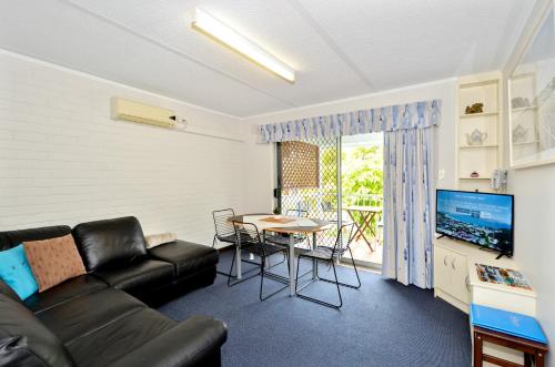 a living room with a black couch and a table at Dolphin Lodge Albany - Self Contained Apartments at Middleton Beach in Albany