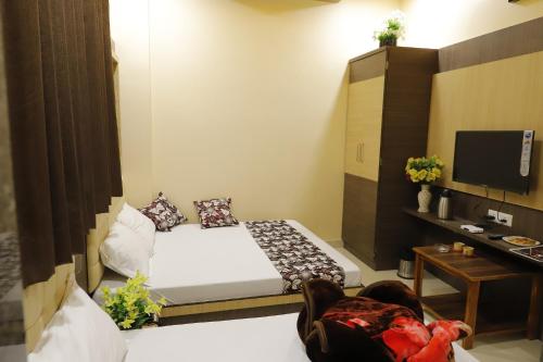 a hotel room with a bed and a tv at Hotel Royal Suites in Ajmer