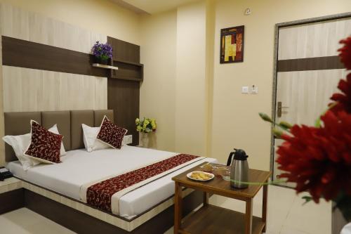a bedroom with a bed and a table with flowers at Hotel Royal Suites in Ajmer
