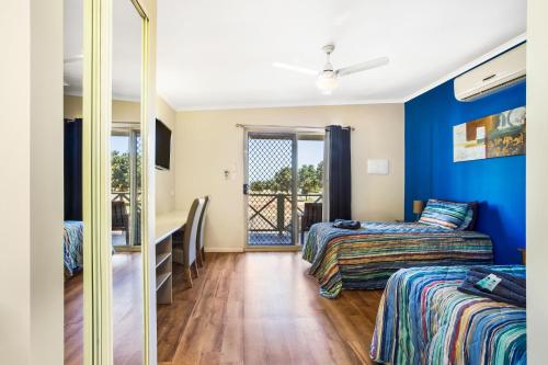 Zimmer mit 2 Betten und einem Spiegel in der Unterkunft The Cove Holiday Village in Point Samson