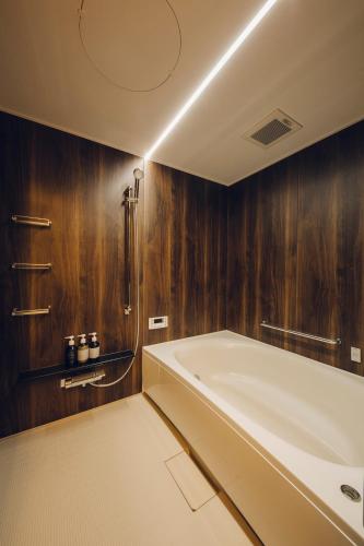 a bathroom with a large tub and wooden walls at Asahi House Kyoto Dog Friendly in Kyoto