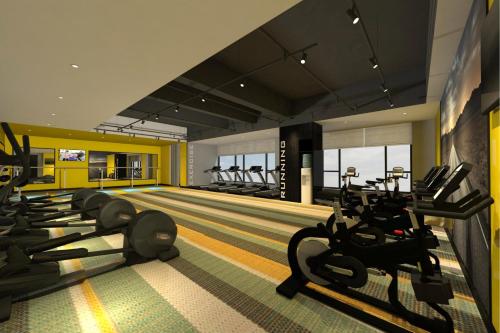 a gym with a row of treadmills and exercise bikes at Citadines Gaoke Liangjiang Chongqing in Chongqing
