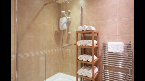 a bathroom with a shower and a toilet and towels at The Cottage in Aberdeen