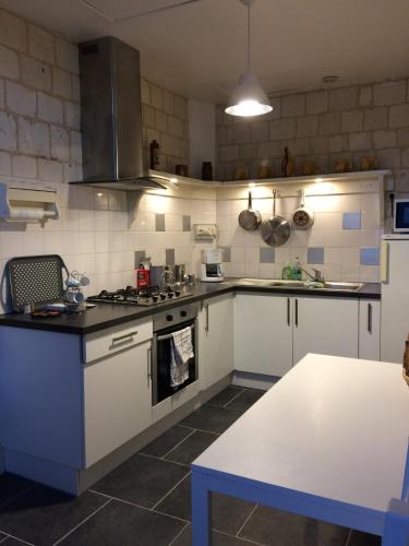 une cuisine avec des armoires blanches et un four à plaques de cuisson dans l'établissement le chateau de PENIN, à Penin