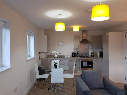 a kitchen and living room with a couch and a table at 9 Royal View Apartment in Stirling