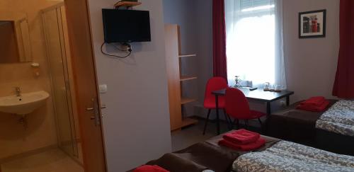 Cette chambre comprend 2 lits, une table et un lavabo. dans l'établissement Pension STELLA, à Lutherstadt Eisleben