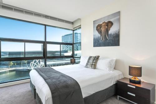 una camera da letto con un letto e una grande finestra di Waterfront Melbourne Apartments a Melbourne