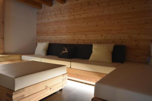 a living room with wooden walls and a couch at Maso Stella in Castello Tesino