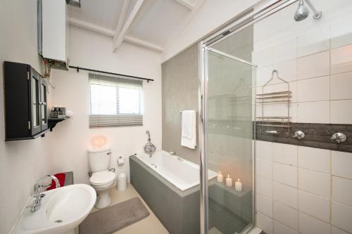 a bathroom with a tub and a toilet and a sink at Route 40 in Hoedspruit