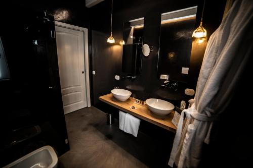 a black bathroom with two sinks and a mirror at Hotel Villa Flora Relais in Caltanissetta