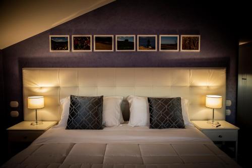 a bedroom with a large bed with two lamps at Hotel Villa Flora Relais in Caltanissetta