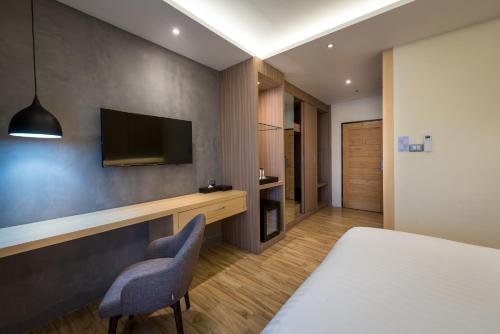 a bedroom with a bed and a tv on a wall at Nadee 10 Resort & Hotel in Khon Kaen