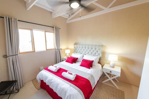 a bedroom with a large bed with red pillows at Route 40 in Hoedspruit