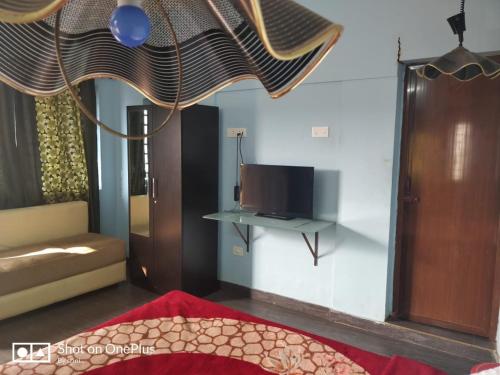 sala de estar con sofá y TV en AARRAAMS Farms & Resorts, en Masinagudi