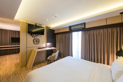 a hotel room with a bed and a desk at Nadee 10 Resort & Hotel in Khon Kaen