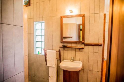 a bathroom with a sink and a mirror at Hôtel Restaurant Coco Lodge Majunga in Mahajanga