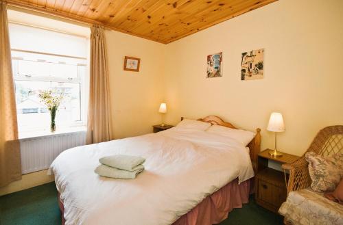 a bedroom with a white bed and a window at Castlehouse B&B in Renvyle