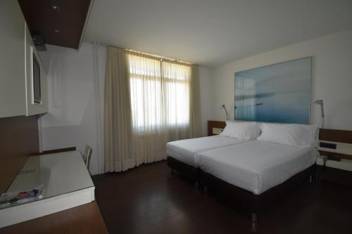 a hotel room with a bed and a window at Hotel Los Angeles in Guarnizo
